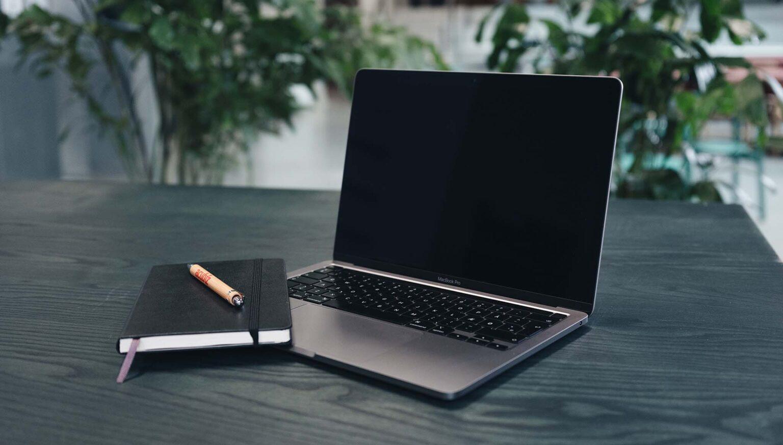 Computer auf dem Schreibtisch mit Notizblock