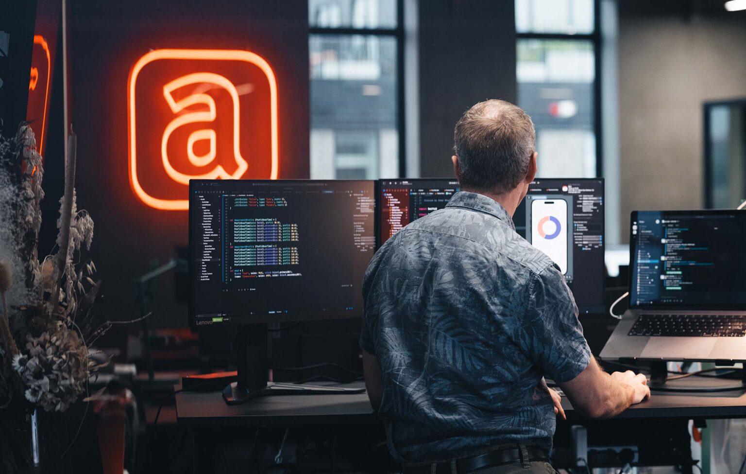 Man working with 2 screens